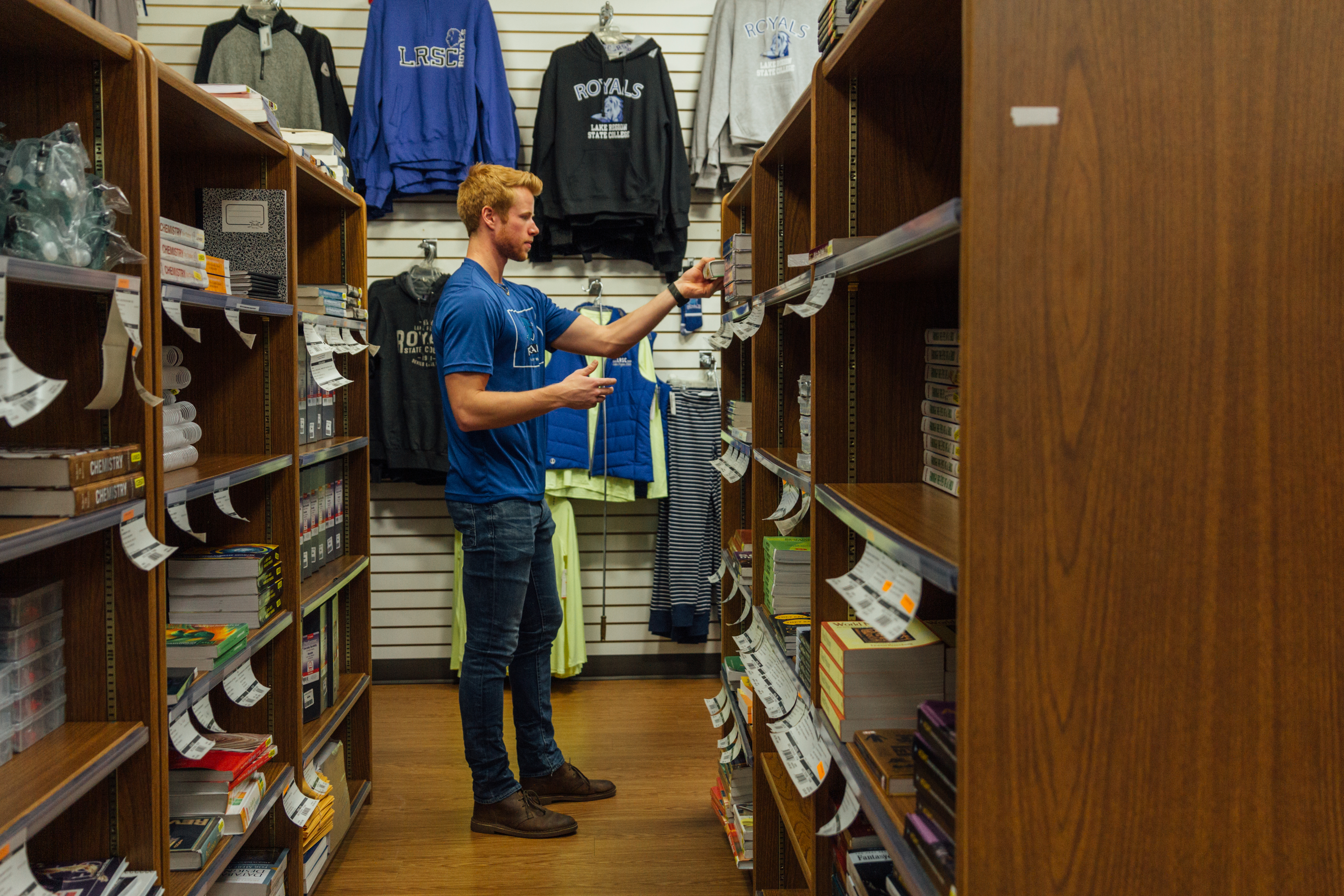Male student standing near textbooks in Bookstore